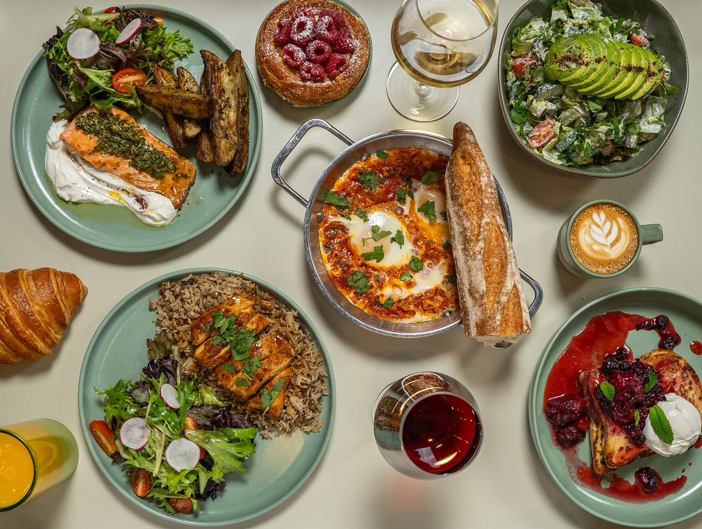 Full spread of dishes at Madame Olivia: salmon, shakshuka, croissants, French toast, latte art