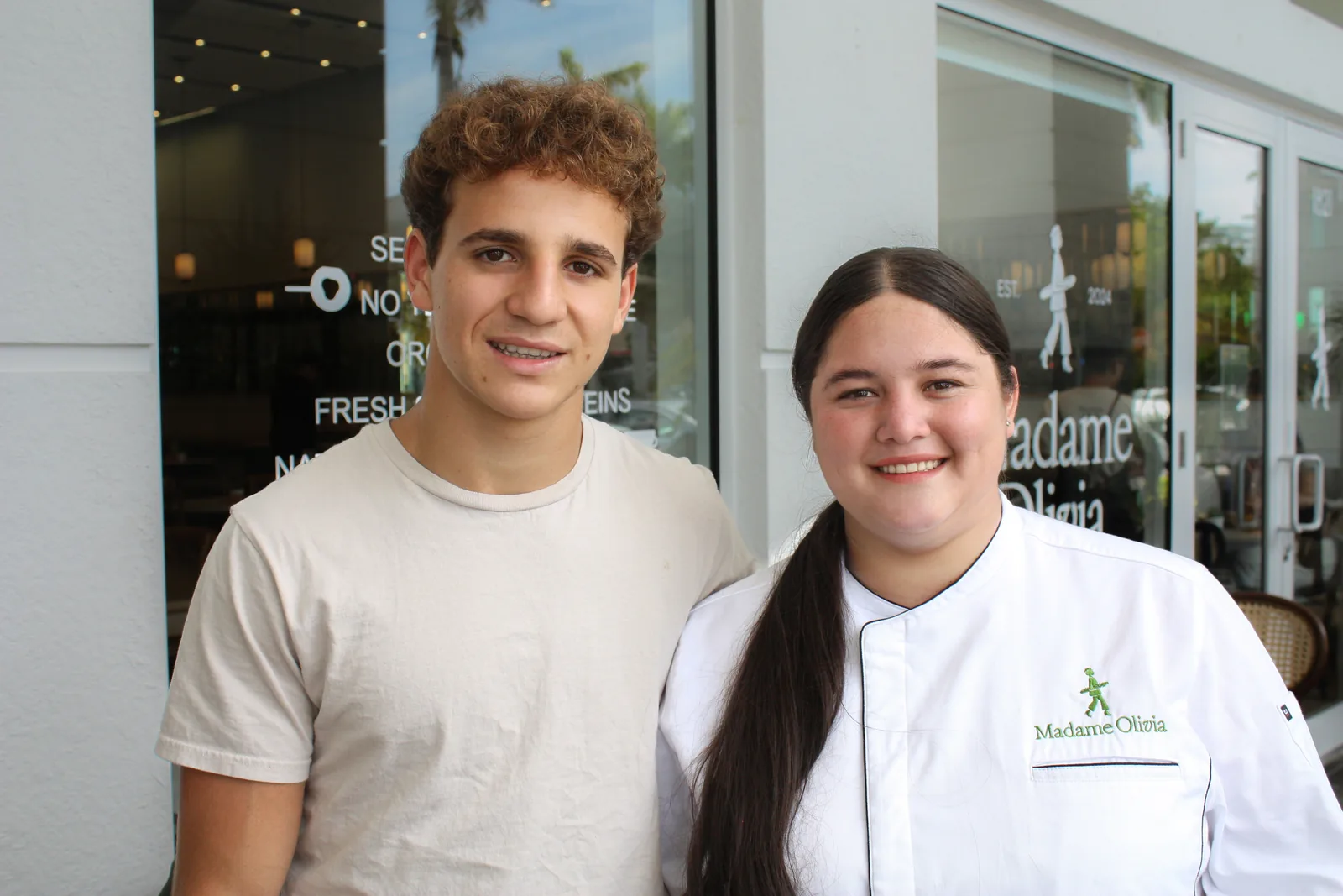 Two Madame Olivia team members in front of the storefront